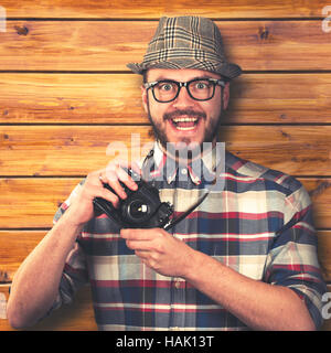 Vintage-Stil glücklich lächelnde Hipster mit Retro-Kamera in Händen Stockfoto