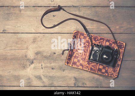 Retro-Kamera mit Vintage Photo Album auf hölzernen Hintergrund Stockfoto