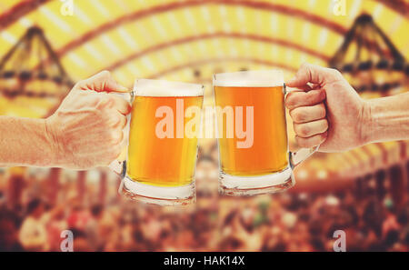 Cheers, zwei Glas-Bierkrüge in Händen Stockfoto