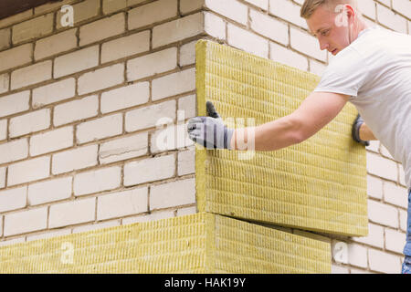 Bauarbeiter, die Fassade des Hauses mit mineralischen Steinwolle Dämmung Stockfoto