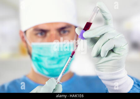 Blutanalyse - Arzt mit Spritze vor Gesicht Stockfoto