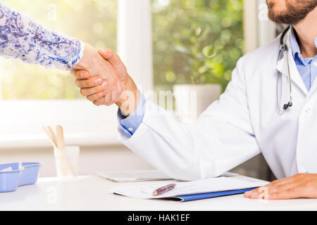 Arztbesuch - schüttelt Hände mit einem Patienten Stockfoto