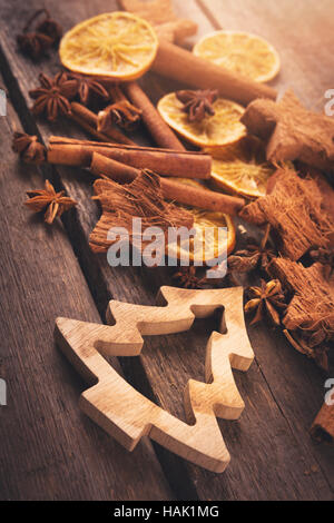 Weihnachtsgruß Kartendesign mit Gewürzen und Weihnachtsbaum auf Holztisch Stockfoto