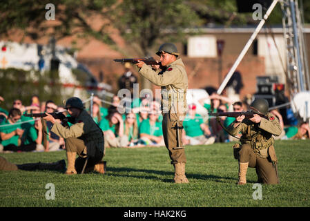 US Army Twilight Tattoo Performance Joint Base Myer Henderson Hall Arlington Virginia // ARLINGTON, Virginia — Soldaten in historischen Militäruniformen, wahrscheinlich aus der Zeit des Zweiten Weltkriegs, führen während der Twilight Tattoo Performance der US Army eine simulierte Feuerdemonstration durch. Dieser kostenlose, öffentliche Militärwettbewerb findet auf dem Gelände der Joint Base Myer-Henderson Hall statt und zeigt die Präzision und Disziplin der zeremoniellen Einheiten der US-Armee. Zu den teilnehmenden Einheiten gehören das 3. US-Infanterieregiment (The Old Guard) und die US-Army-Band Pershing’s Own. Stockfoto