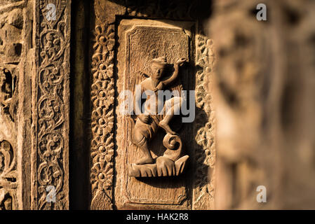 MANDALAY Myanmar // MANDALAY, Myanmar — Tanzfiguren aus Teakholz im Shwenandaw Kloster (auch bekannt als Shwe Nandaw Kyaung), dem einzigen noch erhaltenen ursprünglichen Holzbau aus dem Mandalay Royal Palace Komplex. Das 1878 erbaute Kloster war ursprünglich König Mindon Mindons private königliche Wohnung, in der er starb, und wurde dann von König Thibaw Min innerhalb von Tagen nach dem Tod seines Vaters in ein buddhistisches Kloster umgewandelt. Das Gebäude wurde 1857 von Elefanten aus dem Amarapura-Palast entfernt, als die Hauptstadt nach Mandalay zog. Konstruiert Stockfoto