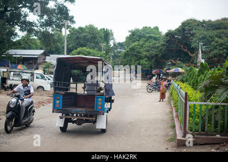 Mingun Village Street Scene Mandalay Region Myanmar // MINGUN, Myanmar — Eine Straße im Dorf Mingun in der Region Mandalay von Myanmar. Mingun liegt am Ayeyarwady River (auch bekannt als Irrawaddy River) etwa 11 Kilometer nordwestlich von Mandalay. Das Dorf ist weithin bekannt für seine archäologischen Stätten, einschließlich der unvollendeten Mingun Pahtodawgyi Pagode und der Mingun Glocke. Mingun ist ein beliebtes Reiseziel für Besucher, die das kulturelle Erbe rund um Mandalay erkunden. Das Dorf ist mit dem Boot von Mandalay aus erreichbar, mit regelmäßigen Fährverbindungen Stockfoto