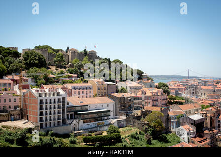 Schloss São Jorge und Stadtbild von Lissabon // LISSABON, Portugal - Blick auf die Stadt Lissabon und den Fluss Tejo, von den Mauern des Schlosses aus nach Westen. Hoch oben auf einem Hügel mit Blick auf das Zentrum von Lissabon, ist die Burg São Jorge (oder Castelo de São Jorge oder St. George Castle) eine maurische Burg. Befestigungen existieren hier seit Tausenden von Jahren, und die heutigen markanten Mauern stammen aus dem 14. Jahrhundert. Stockfoto