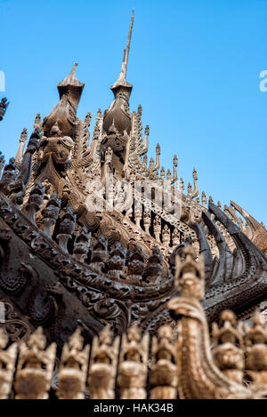 Shwenandaw Kloster Holzschnitzereien Mandalay Myanmar // MANDALAY, Myanmar – aufwändig geschnitzte Holzfiguren säumen die Dachlinie und das Geländer des Shwenandaw Klosters (auch bekannt als Shwe Nandaw Kyaung) und zeigen traditionelle buddhistische architektonische Kunstfertigkeit von Birma. Das Kloster wurde 1878 aus Teakholz erbaut und ist das einzige erhaltene originale Holzgebäude aus dem Königspalast Mandalay. Das Gebäude war ursprünglich König Mindon Mindons private königliche Wohnung, wo er 1878 starb, und dann von König Thibaw Min innerhalb von 31 Tagen nach dem Tod seines Vaters in ein buddhistisches Kloster umgewandelt. Das Kloster Stockfoto