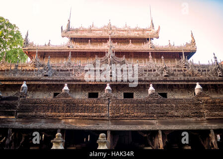 Shwenandaw Kloster Teakholzschnitzereien Mandalay Myanmar // MANDALAY, Myanmar – das Äußere des Shwenandaw Klosters (auch bekannt als Shwe Nandaw Kyaung) zeigt komplexe Teakholzschnitzereien, die buddhistische Mythologie und Jataka-Geschichten darstellen. Das 1878 erbaute Kloster war ursprünglich König Mindon Mindons private königliche Wohnung im Mandalay Palace Komplex, bevor es nach dem Tod des Königs in ein buddhistisches Kloster umgewandelt wurde. Das Gebäude stellt das einzige erhaltene ursprüngliche Holzgebäude aus dem königlichen Palast dar und wurde vollständig aus Teakholz mit traditionellen Einsteckstutzen und Tenon Joi gebaut Stockfoto