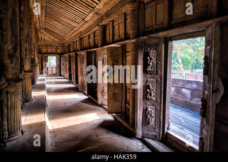 MANDALAY Myanmar // MANDALAY, Myanmar — Ein mit Teakholz gesäumter Saal zeigt die komplizierten Holzarbeiten im Shwenandaw Kloster (auch bekannt als Shwe Nandaw Kyaung), der einzigen erhaltenen ursprünglichen Holzkonstruktion aus dem Mandalay Royal Palace Komplex. Das 1878 erbaute Kloster war ursprünglich König Mindon Mindons private königliche Wohnung, wo er 1878 starb, und dann von König Thibaw Min innerhalb von 31 Tagen nach dem Tod seines Vaters in ein buddhistisches Kloster umgewandelt wurde. Das Gebäude wurde erstmals als Teil des Amarapura-Palastes während der Konbaung-Dynastie errichtet und von Elefanten transportiert Stockfoto