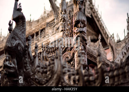 Holzschnitzereien Mandalay Myanmar // MANDALAY, Myanmar — komplizierte Holzschnitzereien zieren das Außengeländer des Shwenandaw Monastery (auch bekannt als Shwe Nandaw Kyaung), der einzigen erhaltenen ursprünglichen Holzkonstruktion aus dem Mandalay Royal Palace Komplex. Das 1878 aus geschnitztem Teakholz erbaute Kloster war ursprünglich König Mindon Mindons private königliche Wohnung, in der er starb, und wurde dann von König Thibaw Min innerhalb weniger Tage nach dem Tod seines Vaters in ein buddhistisches Kloster umgewandelt. Das Gebäude wurde zunächst als Teil des Amarapura-Palastes errichtet, dann abgebaut und von Elefanten dorthin transportiert Stockfoto