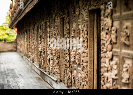 Holzschnitzereien Mandalay Myanmar // MANDALAY, Myanmar — komplizierte dekorative Schnitzereien zieren die Außenwand des Shwenandaw Klosters (auch bekannt als Shwe Nandaw Kyaung), die einzige erhaltene originale Holzkonstruktion aus dem Mandalay Royal Palace Komplex. Das 1878 aus geschnitztem Teakholz erbaute Kloster war ursprünglich König Mindon Mindon Minds private königliche Wohnung, wo er 1878 starb und dann von König Thibaw Min in ein buddhistisches Kloster umgewandelt wurde. Das Gebäude war ursprünglich Teil des Amarapura-Palastes, bevor es von e abgebaut und transportiert wurde Stockfoto