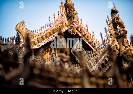 Holzschnitzereien Mandalay Myanmar // MANDALAY, Myanmar — komplizierte Holzschnitzereien zieren die Dachlinie des Shwenandaw Monastery (auch bekannt als Shwe Nandaw Kyaung), der einzigen erhaltenen ursprünglichen Holzkonstruktion aus dem Mandalay Royal Palace Komplex. Das 1878 aus Teakholz erbaute Kloster war ursprünglich König Mindon Mindons private königliche Wohnung, wo er 1878 starb, und wurde dann von König Thibaw Min in ein buddhistisches Kloster umgewandelt. Das Gebäude wurde zuerst als Teil des Amarapura-Palastes während der Konbaung-Dynastie errichtet und wurde demontiert Stockfoto