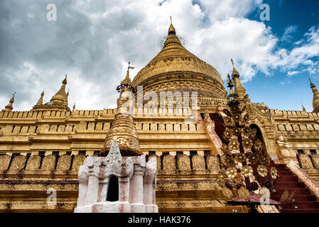 NYAUNG-U, Myanmar (Birma) - erbaut im 11. Jahrhundert, Shwezigon Pagode befindet sich in Nyaung-U, in der Nähe von Bagan. Strahlen Sie von einem großen zentralen Blattgold vergoldeten glockenförmigen Stupa eine Reihe von kleineren Tempeln und Schreinen. Die Stupa ist solide, und die Legende besagt, dass es einen Knochen und Zahn des Gautama Buddha verankert sind. Stockfoto