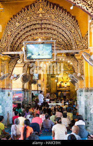 MANDALAY, Myanmar – Mahamuni Buddha Tempel (auch bekannt als Mahamuni Pagoda) ist eine hoch verehrte religiöse Stätte in Mandalay. Im Herzen steht das Mahamuni-Buddha-Bild, das als eines von nur fünf ursprünglichen Ähnlichkeiten des Buddha zu seinen Lebzeiten angesehen werden soll. Es ist mit Goldfolie bedeckt, die von Gläubigen und Pilgern als Tribut gespendet wurde. Stockfoto