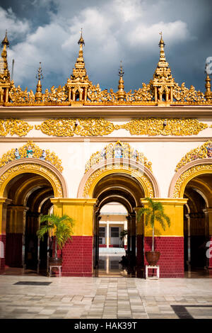 MANDALAY, Myanmar – Mahamuni Buddha Tempel (auch bekannt als Mahamuni Pagoda) ist eine hoch verehrte religiöse Stätte in Mandalay. Im Herzen steht das Mahamuni-Buddha-Bild, das als eines von nur fünf ursprünglichen Ähnlichkeiten des Buddha zu seinen Lebzeiten angesehen werden soll. Es ist mit Goldfolie bedeckt, die von Gläubigen und Pilgern als Tribut gespendet wurde. Stockfoto