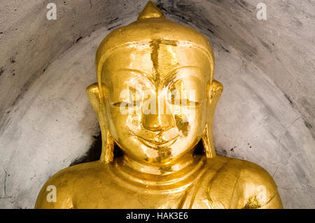 Eine kleine goldene Statue des Buddha in einer Nische an der Thatbyinnyu Tempel. Im 12. Jahrhundert erbaut, thatbyinnyu Tempel ist einer der bekannteren Tempel in Bagan Archäologische Zone und steht neben dem berühmten Ananda Tempel. Stockfoto