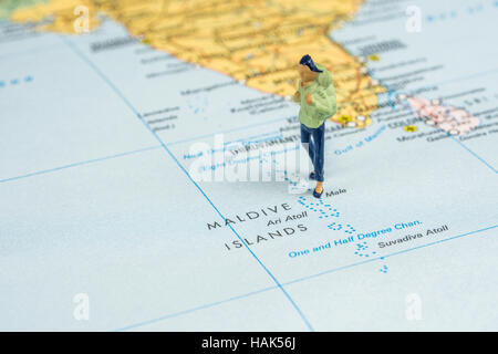 Nahaufnahme von Miniatur Figur des jungen Reisenden steht auf große Karte neben Malediven Stockfoto