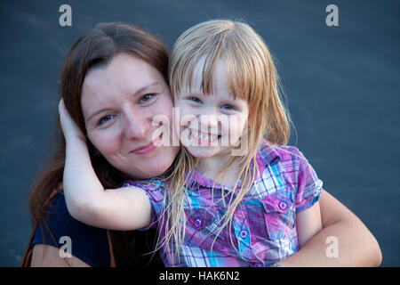 Liebevolle junge Tochter umarmt ihre glückliche Mutter Alter 33 und 5. Champlin Minnesota MN USA Stockfoto