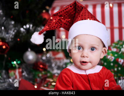 Santa Clause Baby in Gedanken in die Kamera schaut Stockfoto