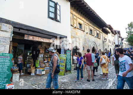 Straße in der Altstadt mit Menschen zu Fuß und Geschäfte in der mittelalterlichen Stadt Santillana del Mar in Kantabrien, Spanien Stockfoto