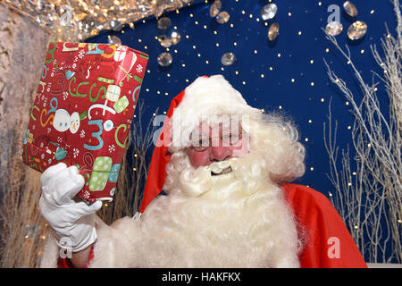 Nikolaus oder Weihnachtsmann, die Geschenke in seiner Grotte austeilen Stockfoto