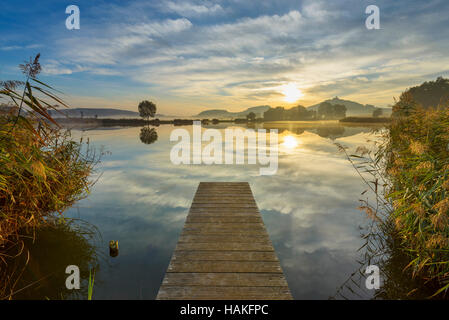 Holzsteg mit reflektierenden Himmel im See bei Sunrise, Drei Gleichen, Ilm-Kreis, Thüringen, Deutschland Stockfoto