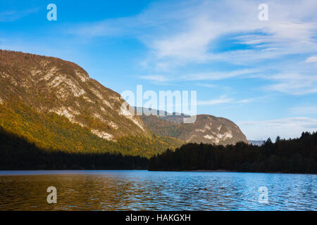 Den See und den Wald mit schönen Farben des Herbstes auf den Pisten der Julischen Alpen unter einem blauen Himmel bei Sonnenuntergang. Slowenien. Stockfoto