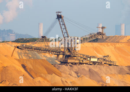 Bergbaumaschinen in einem offenen Braunkohle pit mine. Im Hintergrund sind die Kraftwerke. Stockfoto