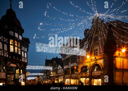 Chester Stadtzentrum Weihnachten Lichter Kreuz Zentrum beschäftigt überfüllt Geschäften tudor Gebäude Architektur Nacht Abend Dämmerung Geschichte geschichtlich Geschäfte s Stockfoto