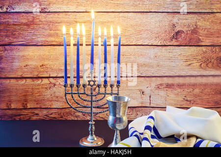 Jüdischer Feiertag Hannukah Symbole - Menora, Donuts, Schokoladen-Münzen und Holz Dreidel jüdischen Feiertages Chanukka mit menorah Stockfoto