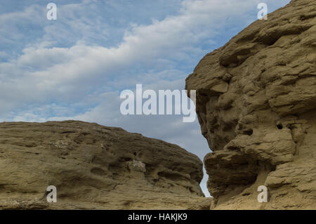 Nahaufnahme von Felsformationen aus Sandstein mit Wasser-Erosion und Witterungsschäden mit blauen Himmel und Cirruswolken im Hintergrund Stockfoto