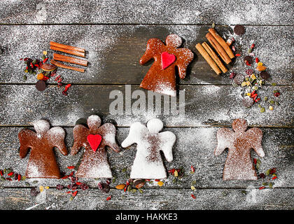 Weihnachtsengel Lebkuchen mit Gewürzen und Nüssen auf einem hölzernen Hintergrund. Ansicht von oben Stockfoto