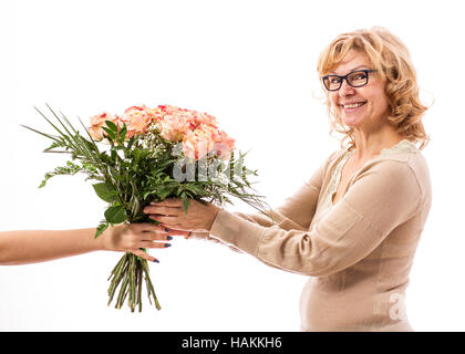 Reife Frau bekommt einen Strauß Rosen, Muttertag, isoliert Stockfoto