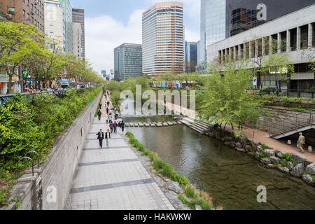 Menschen entlang der Cheonggyecheon Stream und modernen Bürogebäuden in Seoul, Südkorea. Stockfoto