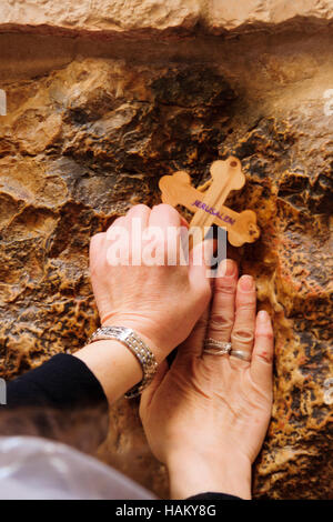 Ein Pilger segnet ein Kreuz mit Jesus Hand drucken, in der Via Dolorosa Station 5, auf orthodoxe Karfreitag in der Altstadt von Jerusalem, Israel Stockfoto