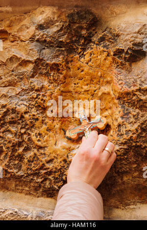 Ein Pilger segnet ein Kreuz mit Jesus Hand drucken, in der Via Dolorosa Station 5, auf orthodoxe Karfreitag in der Altstadt von Jerusalem, Israel Stockfoto