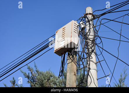 Chaos der elektrischen Kabel und Verteilung Box einen kleinen Mast Stockfoto