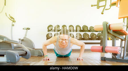 Asia Mann mittleren Alters treiben in der Turnhalle für Stärke, Gewichtsverlust. Stockfoto
