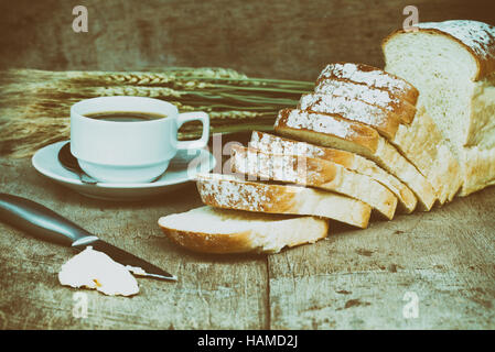 Brot und schwarzen Kaffee und Butter auf Holztisch. Retro-Stil. Stockfoto