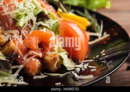 Konzept: Speisekarten, gesundes Essen, hausgemachte, Feinschmecker, Völlerei. Caesar Salat mit Lachs und Cherry Tomaten auf einem verwitterten hölzernen Zeitmessung Stockfoto