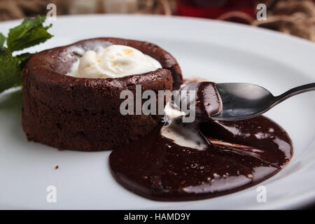 Konzept: Speisekarten, gesundes Essen, hausgemachte, Feinschmecker, Völlerei. Weißen Teller mit Schokolade Fondant und Eis auf einem chaotisch Vintage Holz b Stockfoto