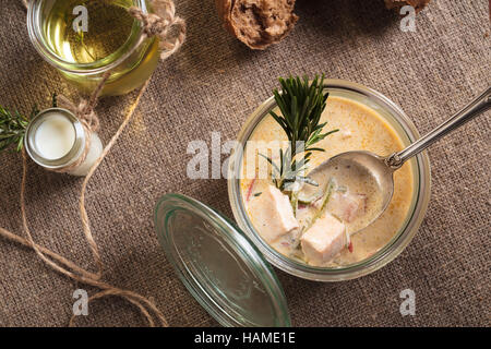 Konzept: Speisekarten, gesundes Essen, hausgemachte, Feinschmecker, Völlerei. Käse-Suppe mit Lachs serviert im Glas mit Zutaten auf sackclot Stockfoto