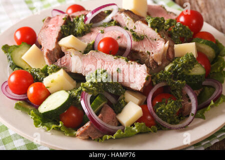 Salat, Gemüse, Käse und Rindfleisch Steak mit Chimichurri Sauce Closeup auf einem Teller. horizontale Stockfoto