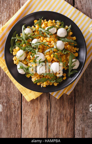 frisch zubereitete Salat von Mais, baby-Mozzarella und Rucola Nahaufnahme auf einer Platte. vertikale Ansicht von oben Stockfoto