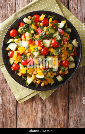 Diätetische Salat von Mais, grünen, Tomaten, Gurken und Pfeffer Nahaufnahme auf dem Tisch. vertikale Ansicht von oben Stockfoto