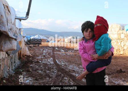 2. Dezember 2016 - sind syrische Flüchtlinge in der Kamuna-Camp für Binnenvertriebene widrigen Wetterbedingungen konfrontiert. Das Camp liegt in der Provinz Idlib, westlich von Aleppo und bis zur türkischen Grenze geschlossen. Mehr Syrer haben ihre Heimat und Städte durch die neuesten Intensivierung der Luftangriffe auf dem Land geflohen. In einem Versuch, die Zuflucht vor den Streiks zu finden haben auch einige Syrer begonnen in Höhlen leben. Seit dem Ausbruch des syrischen Krieges im März 2011, hat die UN geschätzt, 11 Millionen Syrer flohen ihre Heimat, von denen 6 6 Millionen intern werden Vertriebenen wi Stockfoto