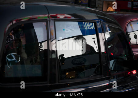 Werbung spiegelt sich in dem Taxi Windows in der Abenddämmerung am Piccadilly Circus, am 1. Dezember 2016, am Piccadilly Circus, London England. Stockfoto