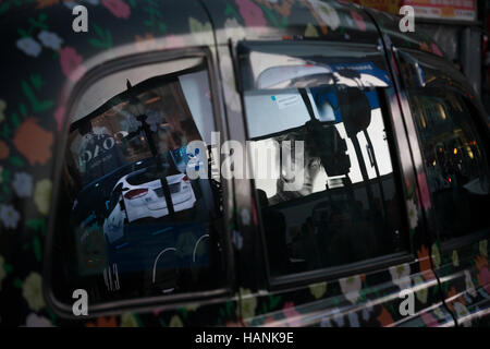 Werbung spiegelt sich in dem Taxi Windows in der Abenddämmerung am Piccadilly Circus, am 1. Dezember 2016, am Piccadilly Circus, London England. Stockfoto