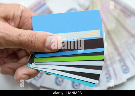 Bankkarten in der Hand auf dem Hintergrund der banknote Stockfoto